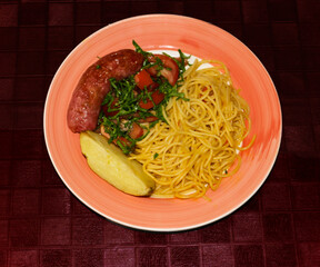 delicious lunch: noodles; sausage, potatoes; cabbage salad with tomato