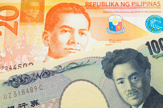 A macro image of a Japanese thousand yen note paired up with a orange and white twenty piso note from the Phillipines.  Shot close up in macro.
