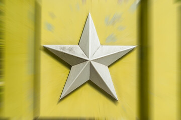 silver metal five pointed Soviet star on a blurred background of light greenish yellow color