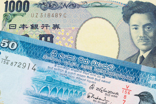 A macro image of a Japanese thousand yen note paired up with a blue and white fifty rupee bank note from Sri Lanka.  Shot close up in macro.