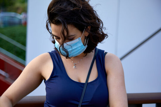 Mujer con mascarilla cabizbaja con flequillo