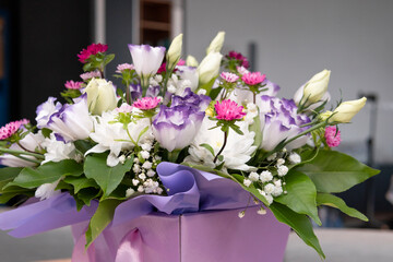 Beautiful luxury bouquets of eustoma and mix flowers in the box, close-up. Bouquet for wedding day or women’s day. Concepts of flower shop and professional florist