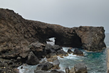 Fototapeta na wymiar Stone arch on the beach in Punta de Arucas, Gran Canaria