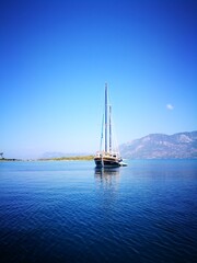 Sailboat in the sea over the mountains background, active vacation in Mediterranean sea, Turkey