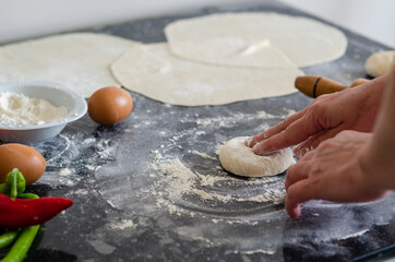 Womans hands, flour and dough. A woman is preparing a dough for home baking