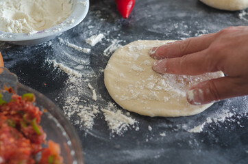 Womans hands, flour and dough. A woman is preparing a dough for home baking