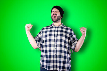 Portrait of a cheerful young man showing okay and victory gesture isolated on the chroma background