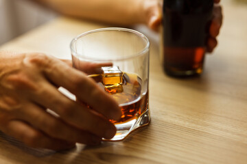 alcoholic hands hold with cognac glass over wooden table close upper view