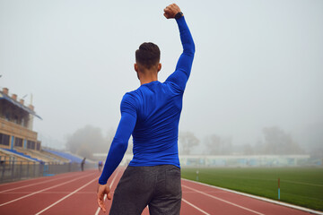 The guy the athlete raised his hands up at the stadium in the fog.