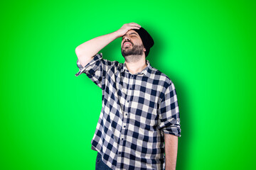 Portrait of a puzzled bearded man holding hands on his head isolated over chroma background