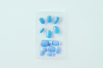 Artificial false nails of blue color in packaging for manicure on white background.