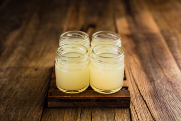 Yellow colored alcoholic shooters, or shot drinks on wooden table