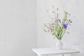 flowers in white vase in white vintage interior