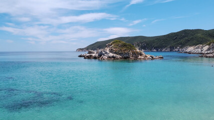 Naklejka premium Mediterranean Greek landscape beach drone shot. Aerial top view of Sithonia Chalkidiki peninsula above rocky coastal with green plantation and crystal-clear waters.