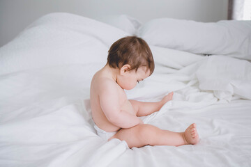 little baby boy in white in bed