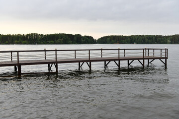 landscape with a pier on the river and forest