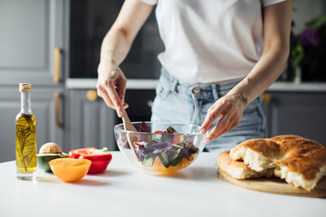 Close-up of the hands of a girl who cuts vegetables for salad. Healthy food