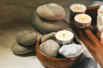 Fototapeta na wymiar Spa composition with essential oil, stones, shell, soft towel, candle. Aromatherapy and relax, atmosphere of serenity and relaxation. Close up, macro view. White wooden background, tonned