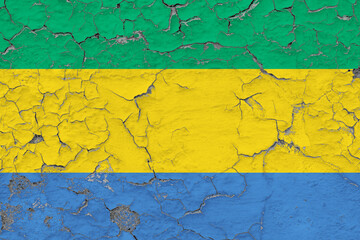 Gabon flag close up grungy, damaged and weathered on wall peeling off paint to see inside surface. Vintage concept.