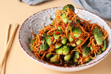 Traditional Korean kimchi snack: cucumbers stuffed with carrots, green onions, garlic and sesame, fermented vegetables, beige background, horizontal format, Closeup