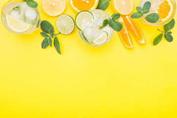 Top view lemonade set. Lemonade, mojito and orange lemonade. Iced summer drink with ingredients on yellow background. Flat lay and copy space.