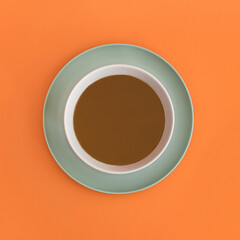 Chocolate bowl on a orange background. Top view. Copy space.