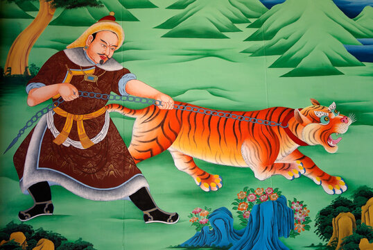 A colorful mural of a man with a chained tiger decorates an interior wall at Songzanlin Tibetan Buddhist monastery, Shangri-La, Yunnan Province, China.