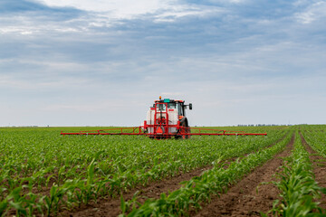 Tractor spraying pesticides at corn fields