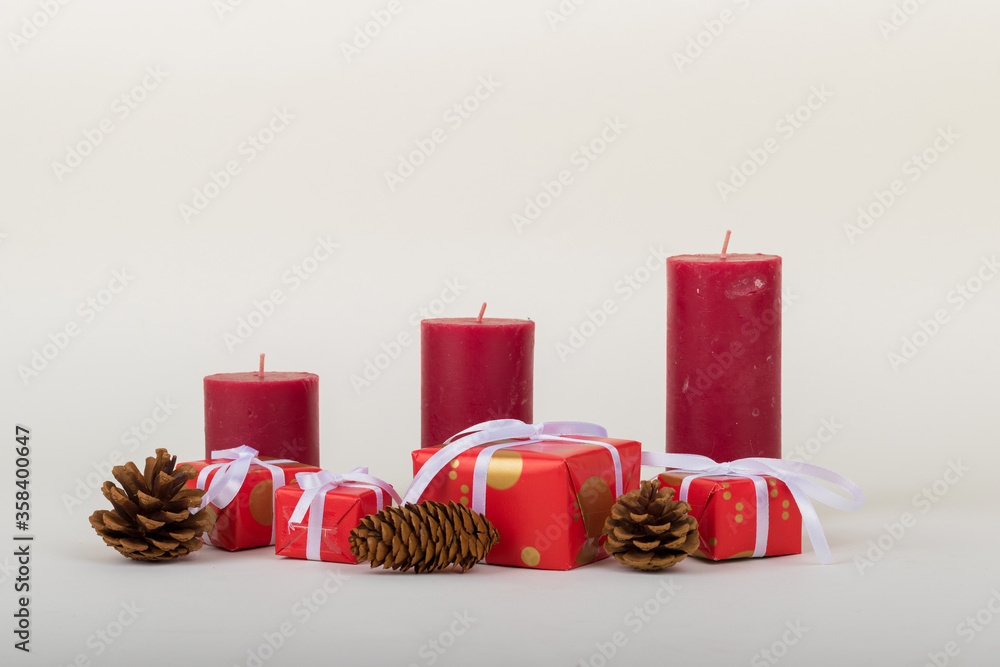 Wall mural christmas holidays composition with decorations, red candles, pine cones and gift boxes on white bac