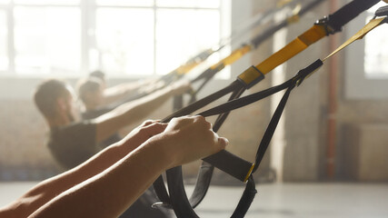 Fitness technology. Close up of hands. Woman doing fitness training exercises at industrial gym....