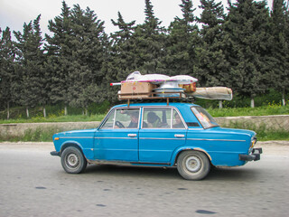 Classic soviet vintage sedan car LADA VAZ 2106 with trunk that is overload by cargo
