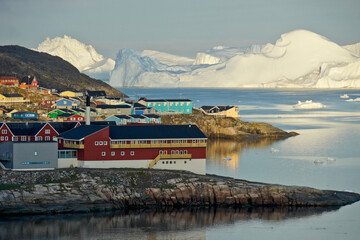 Colorful buildings of Illulissat, Greenland, with icebergs in the background