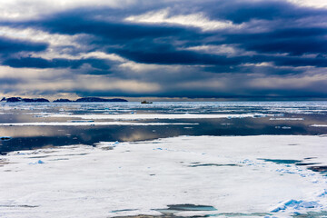 Cloudy sky and Ice pieces on the water in Arctic