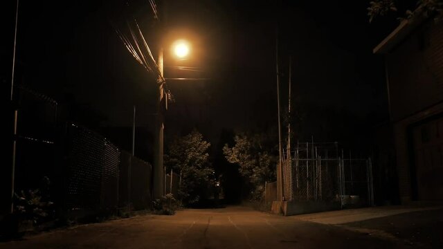Montreal Alleyway, Rosemont, Bordeaux Street - June 12, 2018 - Young man walking alone on an empty dark silent city street at night