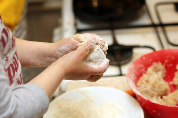 Little children's hands with dough on a blurred kitchen background