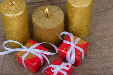 Christmas holidays composition with decorations (gold candles and presents) on white wooden board background with copy space for your text.