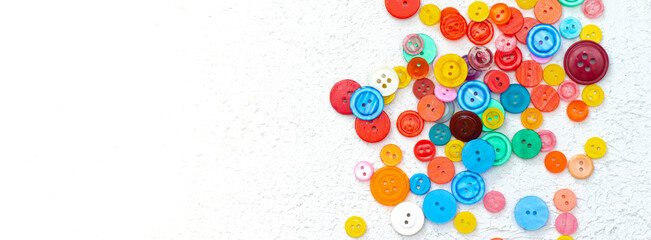Bright buttons a lot on a white background . Sewing and needlework. Colored buttons