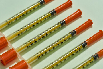 Close up of insulin syringes for diabetes lying diagonally isolated over light background. Injection medicine concept