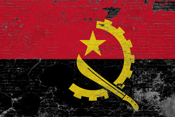 Angola flag on grunge scratched concrete surface. National vintage background. Retro wall concept.