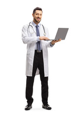 Male doctor standing and using a laptop computer