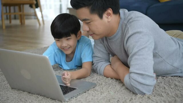Family concept. Parents play notebook with son in the house. 4k Resolution.