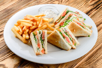 salmon sandwiches and french fries on a white plate