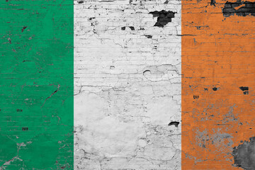 Ireland flag on grunge scratched concrete surface. National vintage background. Retro wall concept.