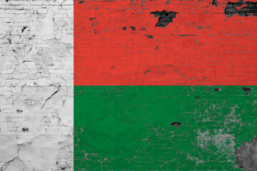 Madagascar flag on grunge scratched concrete surface. National vintage background. Retro wall concept.