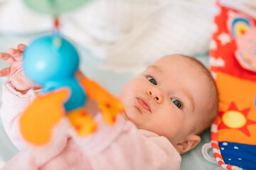 Baby is playing with a mobile. The development of vision of motor skills, concentration under the age of one year