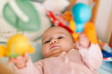 Baby is playing with a mobile. The development of vision of motor skills, concentration under the age of one year