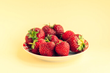 strawberries on a plate on a light background. place for text