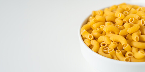 Raw dry uncooked Elbow Macaroni pasta spaghetti on white background. Good for basil tomato pesto sauce Homemade fresh Italian food organic whole wheat vegan spaghetti noodle for a healthy meal