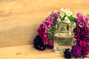 Obraz na płótnie Canvas bouquet of flowers in a glass jar on a wooden background. place for text