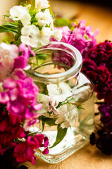 bouquet of flowers in a glass jar on a wooden background. place for text